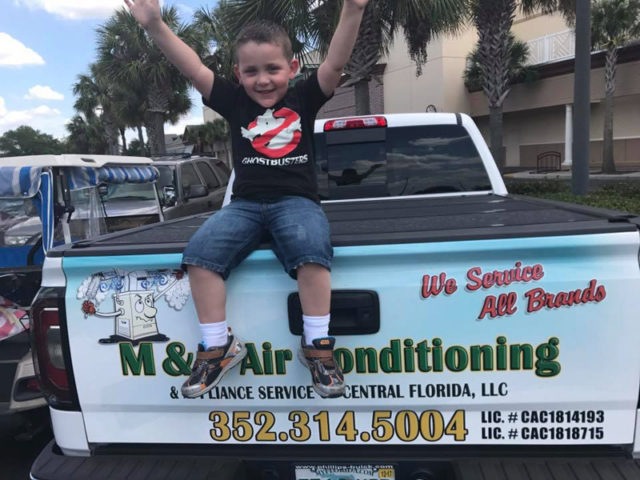 Kid Sitting on Bed of Service Truck